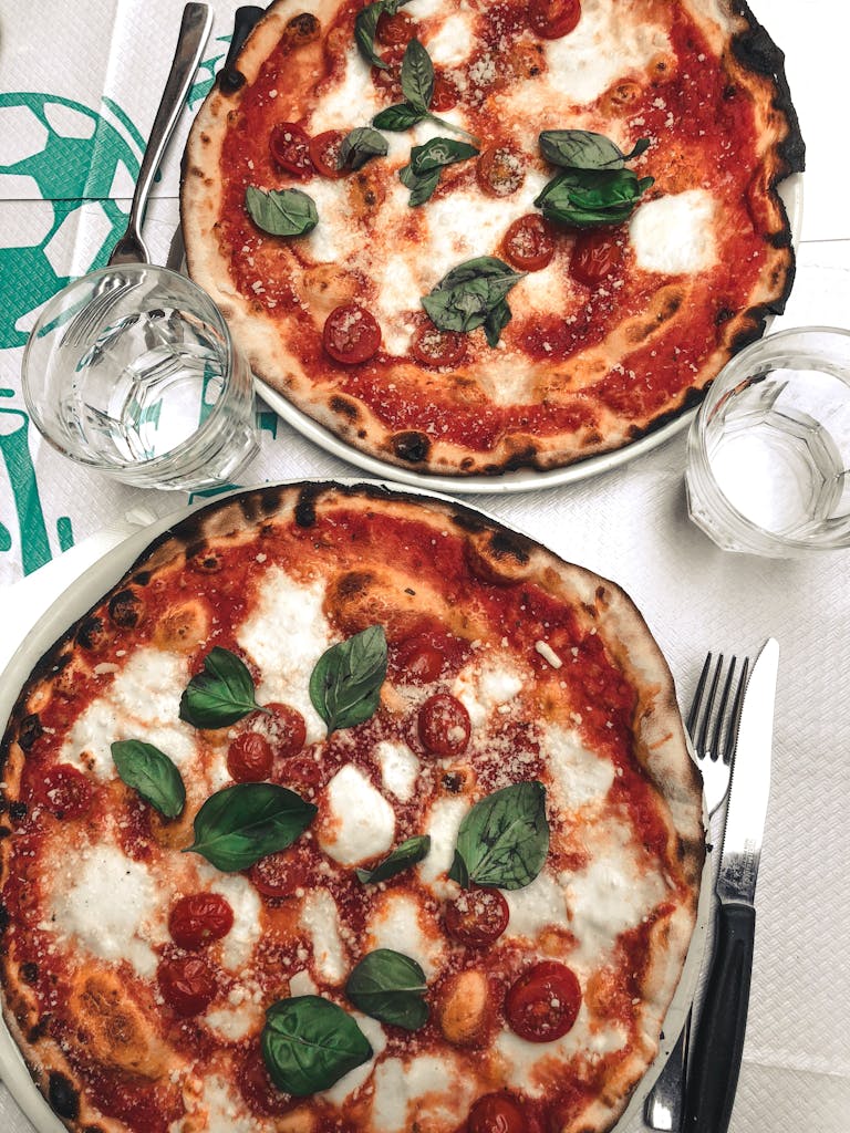 Two delicious sourdough pizzas topped with mozzarella and basil, perfect for a tasty meal.